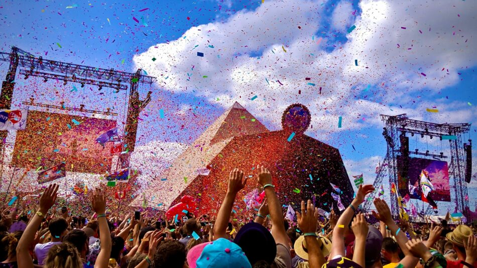 A crowd of people at a music festival in 2023 with confetti in the air.