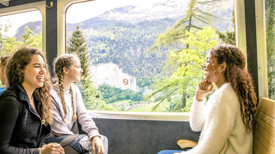 group of friends aboard a train in Swiss Alps