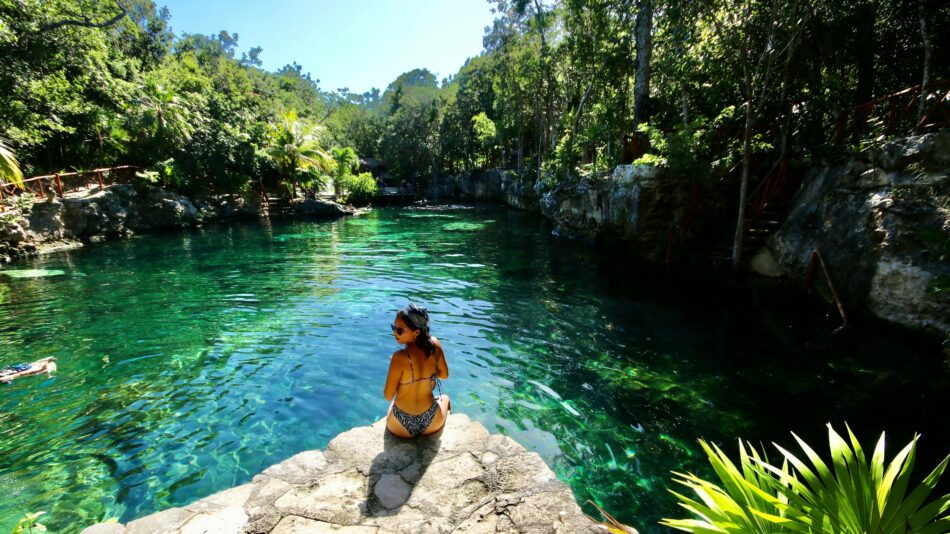 Woman sat by a cenote in Mexico