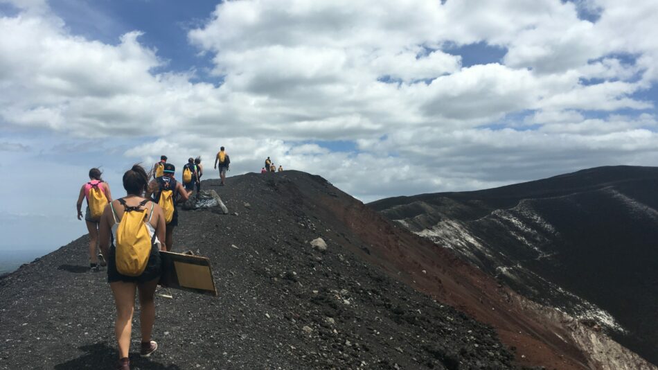 A group of people on an adventure vacation, bravely trekking up the side of a majestic mountain.