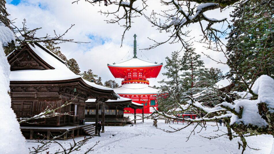 A captivating red pagoda, nestled off the beaten path in Japan, stands majestically amidst a serene landscape blanketed in snow.