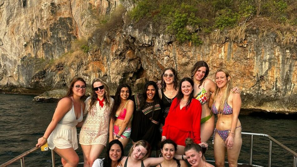 A group of women enjoying social travel on a boat in Thailand.