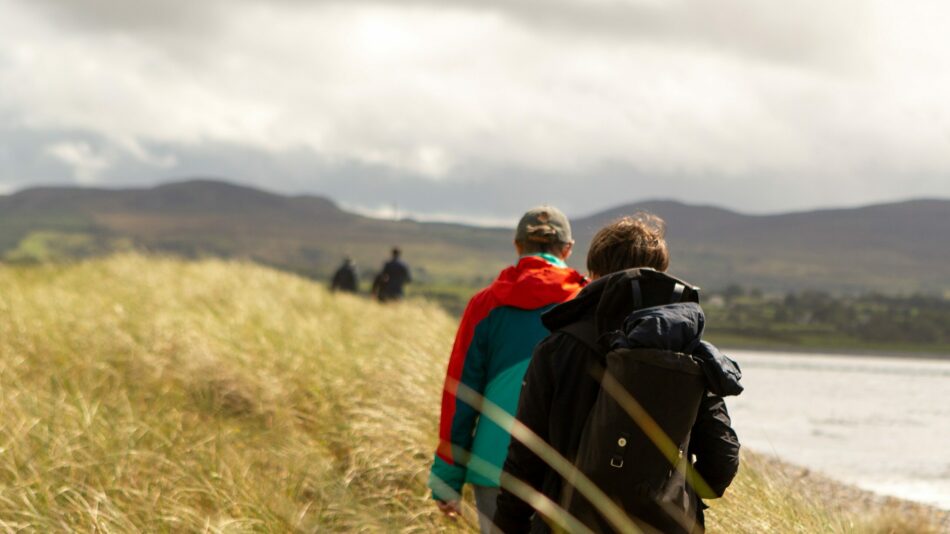 Couple walking over dunes in Sligo, Ireland