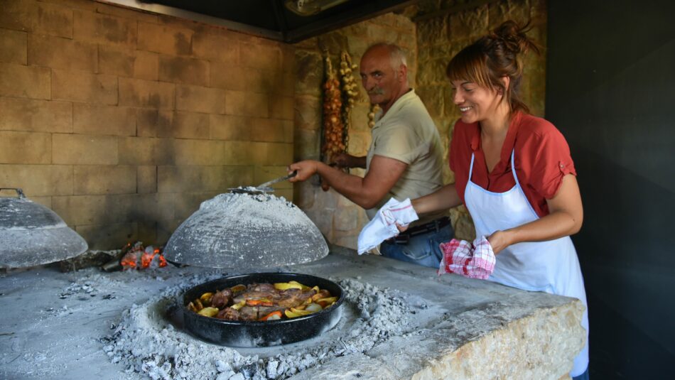 Croatian people cooking in the traditional peka style