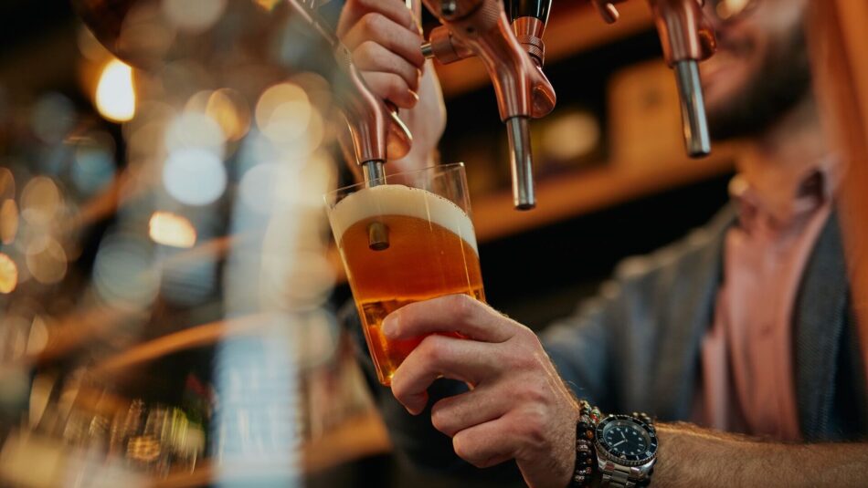 barman pouring a craft beer from a draft