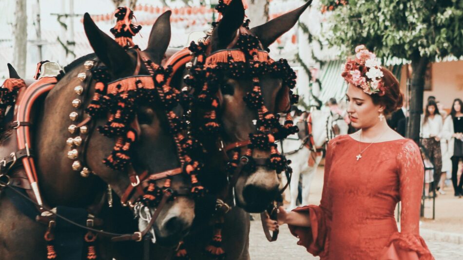 woman in a flamenco dress with horses during Feria in Spain