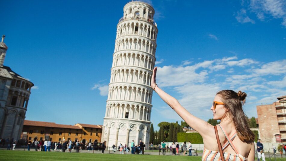 woman posing for an illusion photo at tower of Pisa, Italy