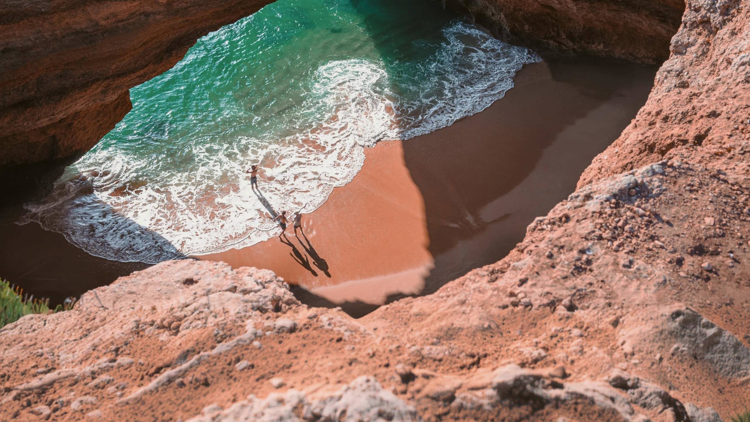 Contiki travellers exploring Benagil Cave on Portugal’s Algarve coast, enjoying the secluded beach and turquoise waters on the Madrid to Lisbon Tour