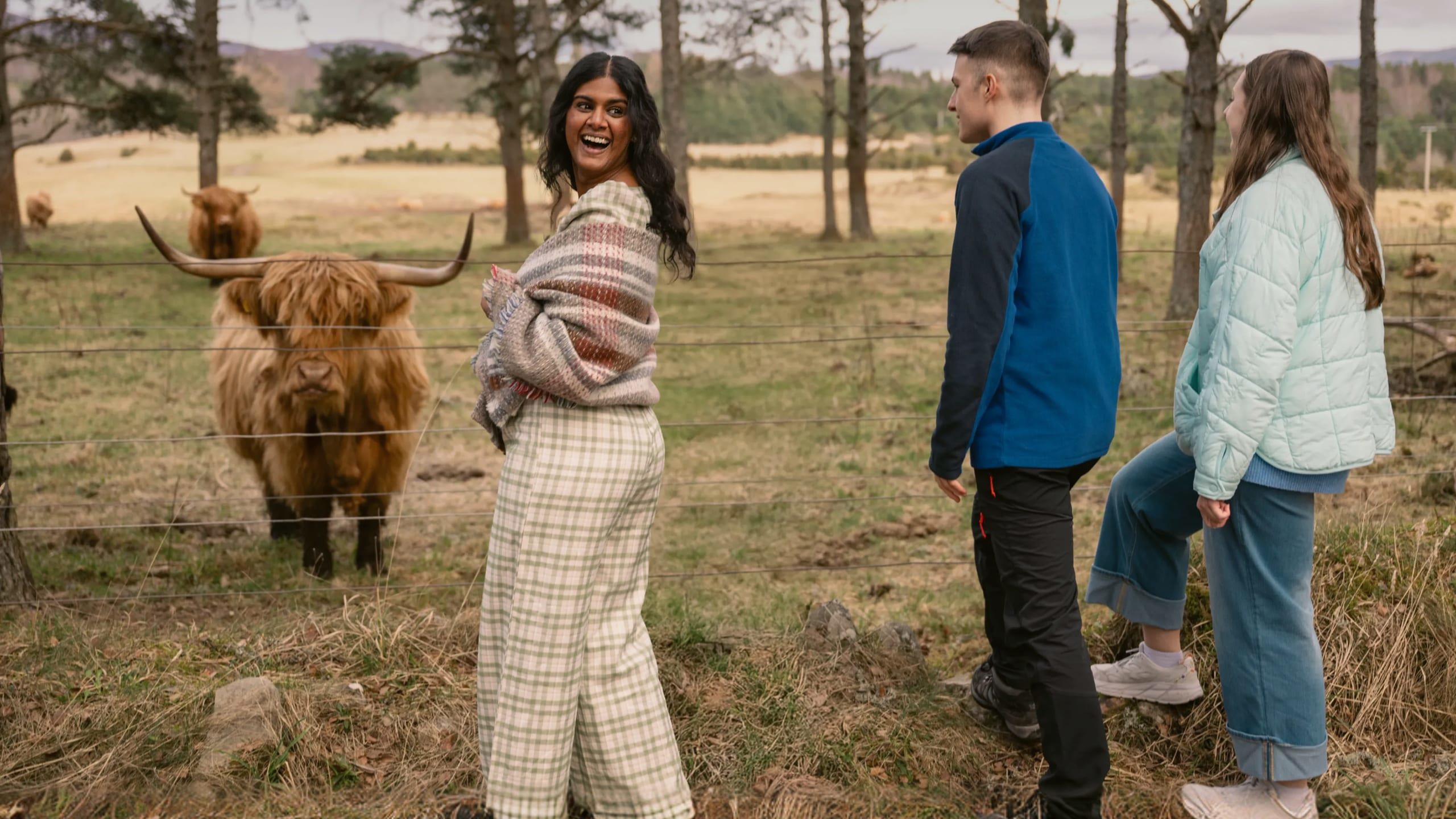 A group meeting a Highland cow in the Scottish Highlands - Contiki Scotland in a Week tour